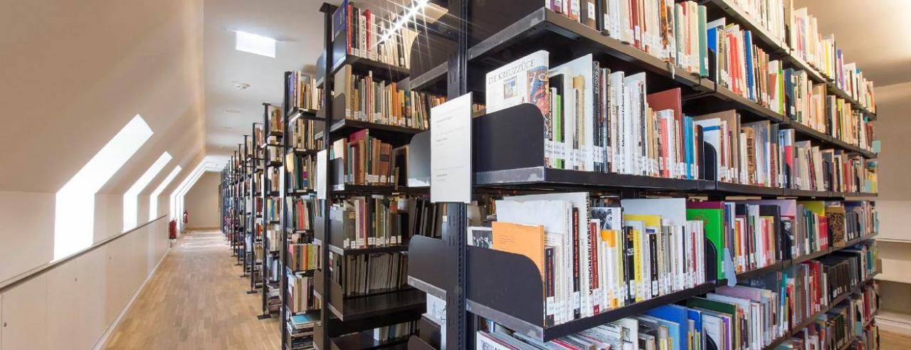 Das Foto zeigt mehrere Regale, auf denen zahlreiche Bücher stehen. 